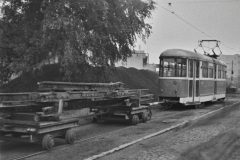 Nákladní souprava pro převoz kolejnic tvořená dvěmi propojenými dvounápravovými podvozky je zapřažena za vůz T1 č. 132. Za pozornost stojí malé tramvajové svítilny na čelech jednotlivých podvozků. 12.10.1980, Michal Režný.